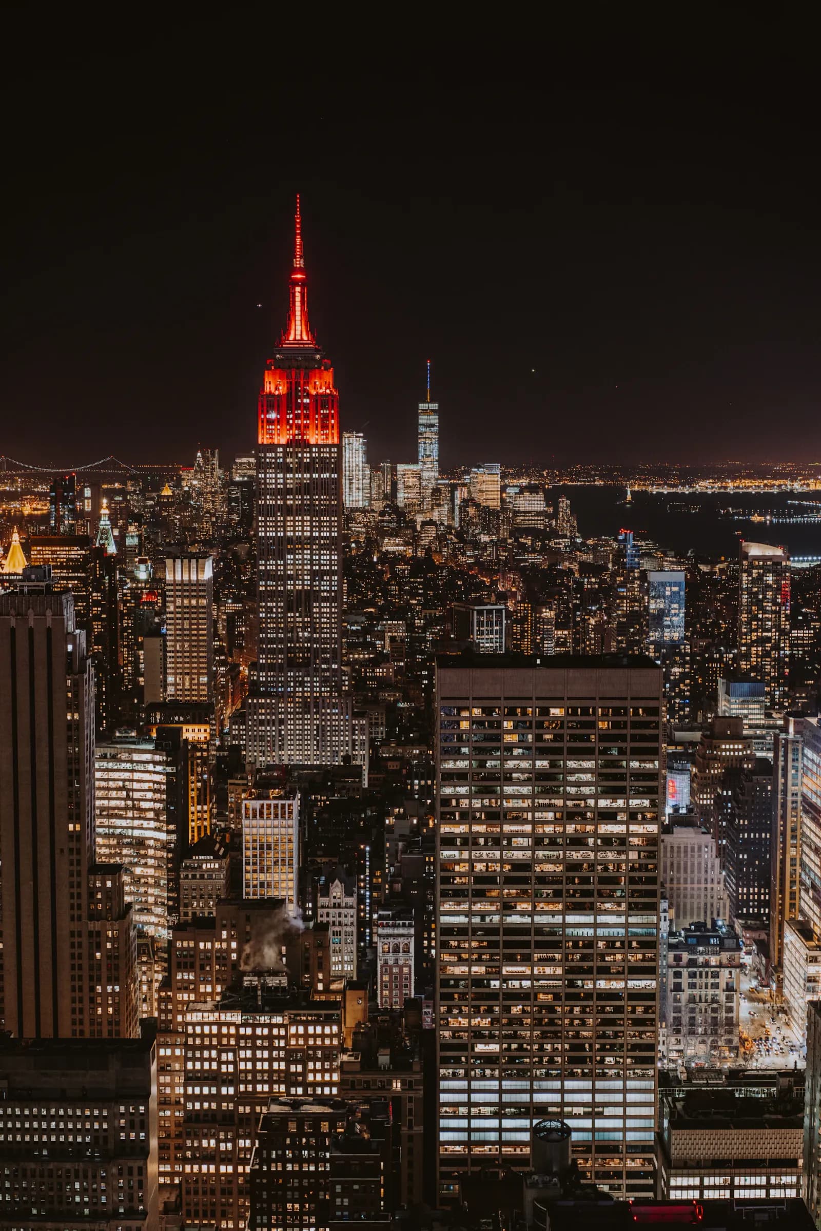 Manhattan at night with the Empire State Building lit red